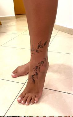 a woman's bare foot with leaves on it and the bottom part of her leg