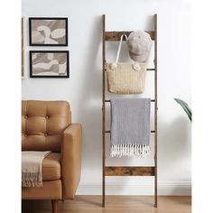 a wooden shelf with two baskets and a blanket on it next to a leather chair