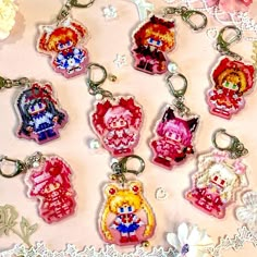 a bunch of key chains that are sitting on a lace doily with flowers in the background