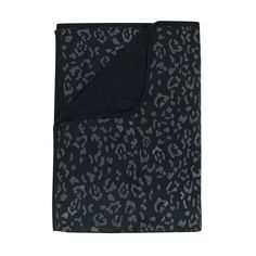 the black and grey leopard print blanket is folded on top of a white background with an animal