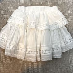 White Layered Mini Skirt With Lace Detail. Skirt Is Slightly Longer In Back And Features An Elastic Waist Band To Easily Accommodate Sizing. Perfect For A Concert Or Back To School! Skirt Has Never Been Worn, Smoke Free Home. White Skirt Ruffle, Cute White Skirts, White Layered Skirt Outfit, Bohemian Cotton Skirt For Brunch, Beach Skirt With Cotton Lace Trim, Beach Skirt With Lace Trim Cotton, Vacation Mini Skirt With Lace Trim, Beach Skirt With Lace Trim In Cotton, Flowy Lace Trim Skirt For Vacation