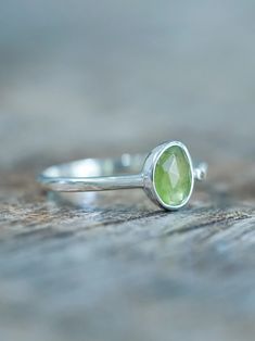 The rose cut peridot (August birthstone) shines alongside a tiny round green sapphire (September birthstone), both held securely in a bezel setting. Pair your peridot ring with peridot earrings to channel a free spirited and joyful vibe. Let this ring be the statement piece that adds a touch of whimsy and elegance to your style. Each piece of our jewelry is handcrafted with love. Lime Green Sterling Silver Birthstone Rings, Green Sapphire Sterling Silver Ring For May Birthstone, Green Sapphire Ring For May Birthstone In Sterling Silver, Green Sapphire Ring Sterling Silver, May Birthstone, Peridot Gemstone Stackable Rings For May Birthstone, Stackable Peridot Gemstone Rings For May Birthstone, Peridot Birthstone Ring With Bezel Setting, Lime Green Peridot Ring For May Birthstone, Peridot Gemstone Stackable Rings