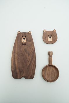 a wooden bear and spoon set next to each other