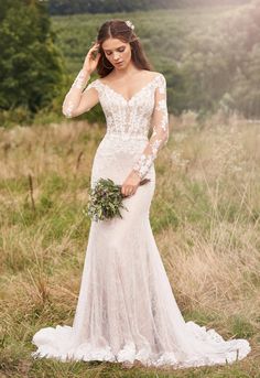 a woman in a wedding dress is standing in the grass with her hand on her head