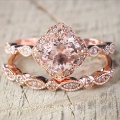 an engagement ring set with a pink diamond in the center and two white diamonds on each band