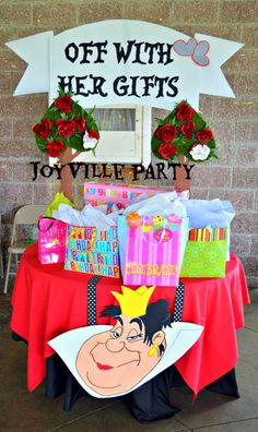 a table with presents on it and a sign that says, off with her gifts joy valley party