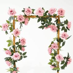 pink roses are growing on the top of a wooden trellis with leaves and stems