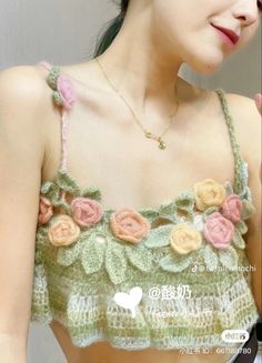 a woman wearing a crochet top with flowers on it's chest and shoulder