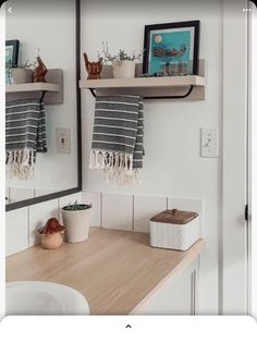 a bathroom sink with two towels hanging on the wall above it and a wooden counter