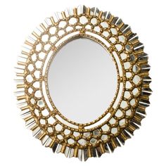 a round mirror with gold trimmings and white stones on the edges, in front of a white background