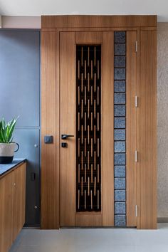 a wooden door is open in a room with blue walls and white flooring, along with a potted plant on the counter