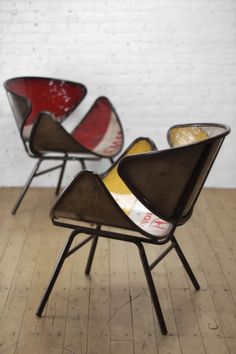 three chairs sitting on top of a wooden floor next to a white brick wall in a room