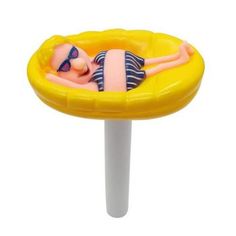 a toy doll laying on top of a yellow floater in the shape of a sunbather