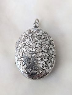 This beautifully hand engraved locket is large at 1 1/2 inches tall by 1 1/4 inches. It is not marked but has been tested and guaranteed to be silver of 925 part per thousand. The locket has some sort of foliage with berries on the front and a gorgeous set of initial at the back, all hand engraved. In lovely condition. C. 1890 and English in origin. Follow me on instagram@jettesjewels Victorian Locket Silver, Collectible Hallmarked Silver Locket Necklace, Antique Engraved White Gold Locket Necklace, Silver Hallmarked Locket Necklace Collectible, Antique Etched Sterling Silver Locket Necklace, Antique Sterling Silver Etched Locket Necklace, Vintage Etched Silver Locket Necklace, Vintage Silver Etched Locket Necklace, Antique Silver Hallmarked Locket Necklace