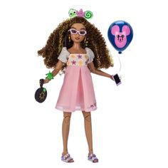 the doll is holding two balloons and a purse in one hand, while wearing a pink dress