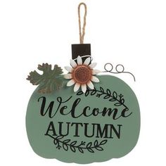 a welcome autumn ornament hanging from a string with a flower on the top