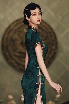 A stunning green and gold qipao dress in vintage style. The gold piping of the Chinese dress decorates the sleeves, mandarin collar, the closure, and the hem of the qipao. This vintage edging creates a contrast with the green color of the qipao dress and adds more visual interest. Green Elegant Cheongsam With Stand Collar, Elegant Green Cheongsam With Stand Collar, Elegant Green Dress With Stand Collar, Elegant Fitted Gold Ao Dai, Elegant Gold Ao Dai, Elegant Gold Fitted Ao Dai, Gold Qipao, Traditional Qipao, China Street Fashion