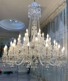 a large chandelier hanging from the ceiling in a room with glass walls and windows