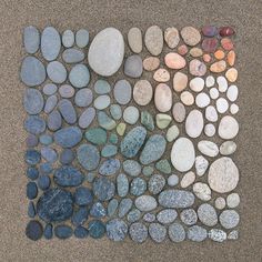 several different colored rocks are arranged in a pattern on the ground, and one is made out of pebbles