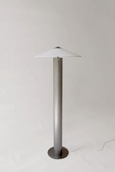 a lamp that is sitting on top of a table next to a white wall and floor