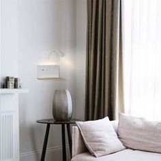 a living room with white walls and curtains