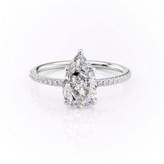 a pear shaped diamond engagement ring on a white background