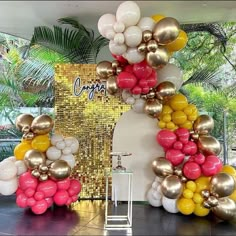 an arch made out of balloons in the shape of flowers