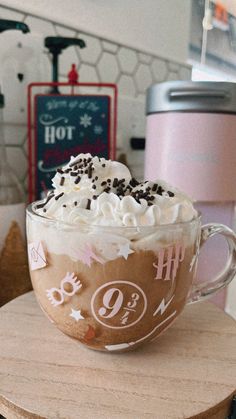 a coffee cup with whipped cream and chocolate sprinkles