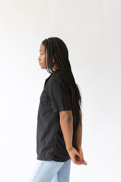 "Vintage black short sleeve shirt with great simple collar, 4 snap buttons, one front rounded patch pocket. Simple addition to any wardrobe and a great transitional piece. Maker: Military Made in the USA in the 60s. Garment Dyed in Los Angeles in 2019. Material: 100% Cotton. Condition: Two Options : Good with some small repairs that include darning. OR Small Holes and scuffs. Not perfect. Measurements: X- SMALL: Shoulder: 16\" | Chest: 17-18\" | Length: 27\" | Sleeve: 9.5\" SMALL: Shoulder: 17\" Washed Black Short Sleeve Tops With Pockets, Short Sleeve Buttoned Tops For Streetwear, Streetwear Short Sleeve Tops With Buttons, Fitted Short Sleeve Black Shirt With Buttons, Short Sleeve Tops With Buttons For Streetwear, Fitted Black Button-up Short Sleeve Shirt, Short Sleeve Shirt With Buttons For Everyday, Fitted Black Short Sleeve Button-up Shirt, Relaxed Fit Short Sleeve Shirt With Buttons