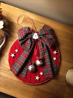 a red and black plaid christmas ornament sitting on top of a wooden table