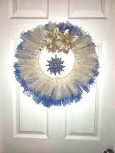 a blue and white wreath hanging on the front door