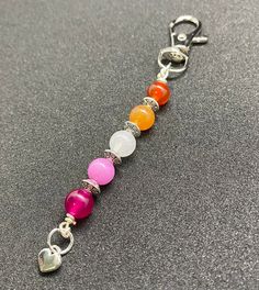 a keychain with seven chakra beads attached to it on a gray surface