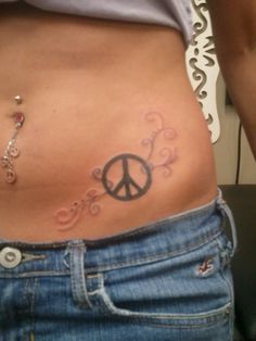 a woman with a peace sign tattoo on her stomach