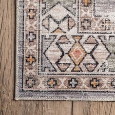 an area rug on a wooden floor with a brown and orange design in the middle