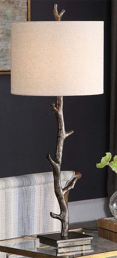 a table with a lamp on top of it next to a book case and vase