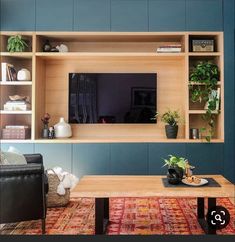 a living room filled with furniture and a flat screen tv mounted on a wall above a coffee table