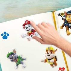 someone is pointing at paw patrol stickers on a book