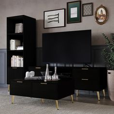 a living room with black furniture and pictures on the wall above it's entertainment center