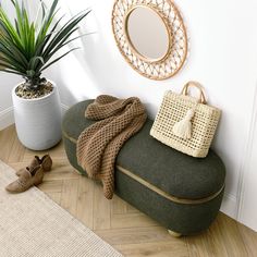 a green bench sitting next to a potted plant on top of a hard wood floor