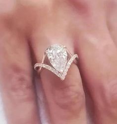 a woman's hand with a diamond ring on top of her finger and an engagement band