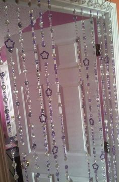 a door with beads hanging from it and a mirror in the back ground behind it