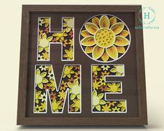 the word home is made out of paper and decorated with yellow flowers on a brown background