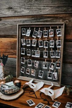 a wooden table topped with pictures and photos next to a basket filled with paper flowers