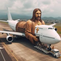 an airplane with a statue of jesus on the front is being loaded by a truck