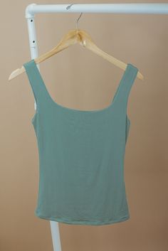 The Double Layered Reg Length Tank is a must-have for a casual summer wardrobe, offering the best basics with its double-layered design that adds a touch of uniqueness to a cute and solid shirt. This stylish and lightweight tank effortlessly embodies a summer aesthetic. Double Layered Tee Fixed straps Premium ribbed knit fabrication Fit: Fitted; Generous stretch Fabric: 92% Nylon 8% Spandex Model Specs: Emily + Karli are wearing a size small in the photo.How will this item fit you? Check out our Stretch Solid Color Summer Tops, Casual Plain Tank Top For Summer, Plain Stretch Tops For Summer, Solid Stretch Summer Tops, Versatile Seamless Summer Top, Green Seamless Summer Tops, Basic Solid Color Summer Tops, Summer Beach Plain Tops, Fitted Tops For Summer Loungewear