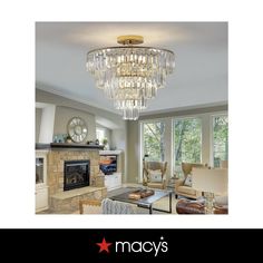 a living room filled with furniture and a chandelier hanging from the ceiling over a fire place