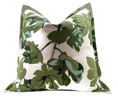 a green and white pillow with leaves on it