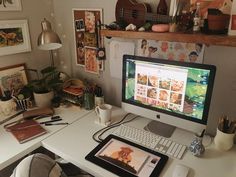 a desk with a computer, keyboard and mouse on it in front of a wall full of pictures