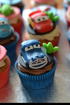 cupcakes with cars on them sitting on a table