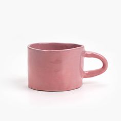 a pink mug sitting on top of a white table